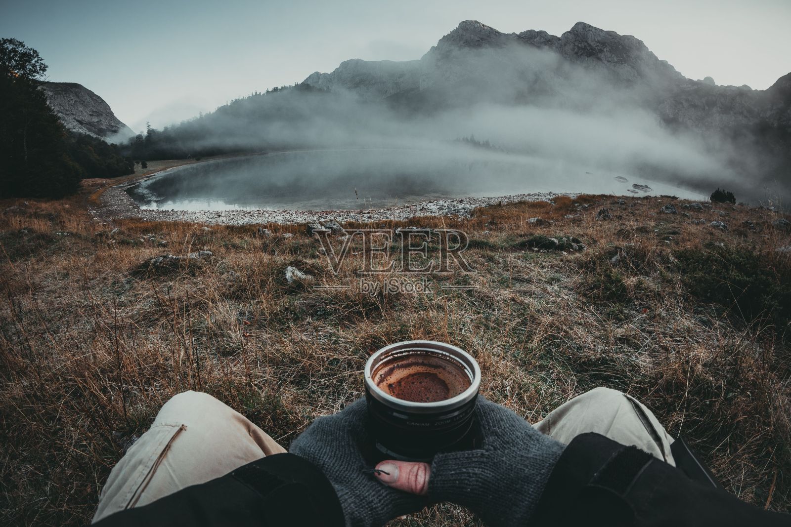 一个人一边喝着咖啡一边欣赏山脉的自然景观照片摄影图片