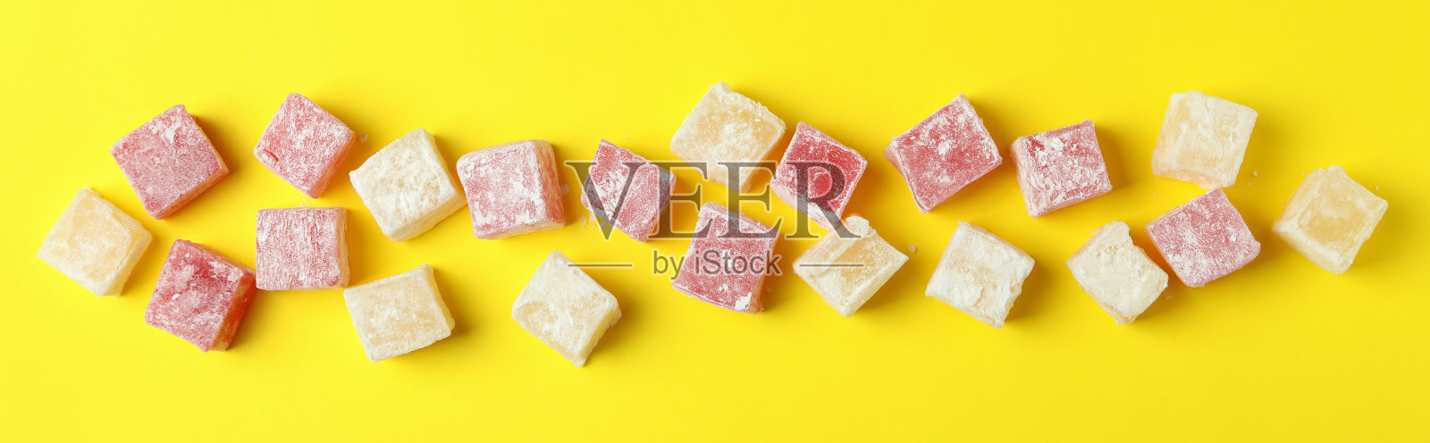 黄色背景上美味的土耳其软糖，俯视图照片摄影图片