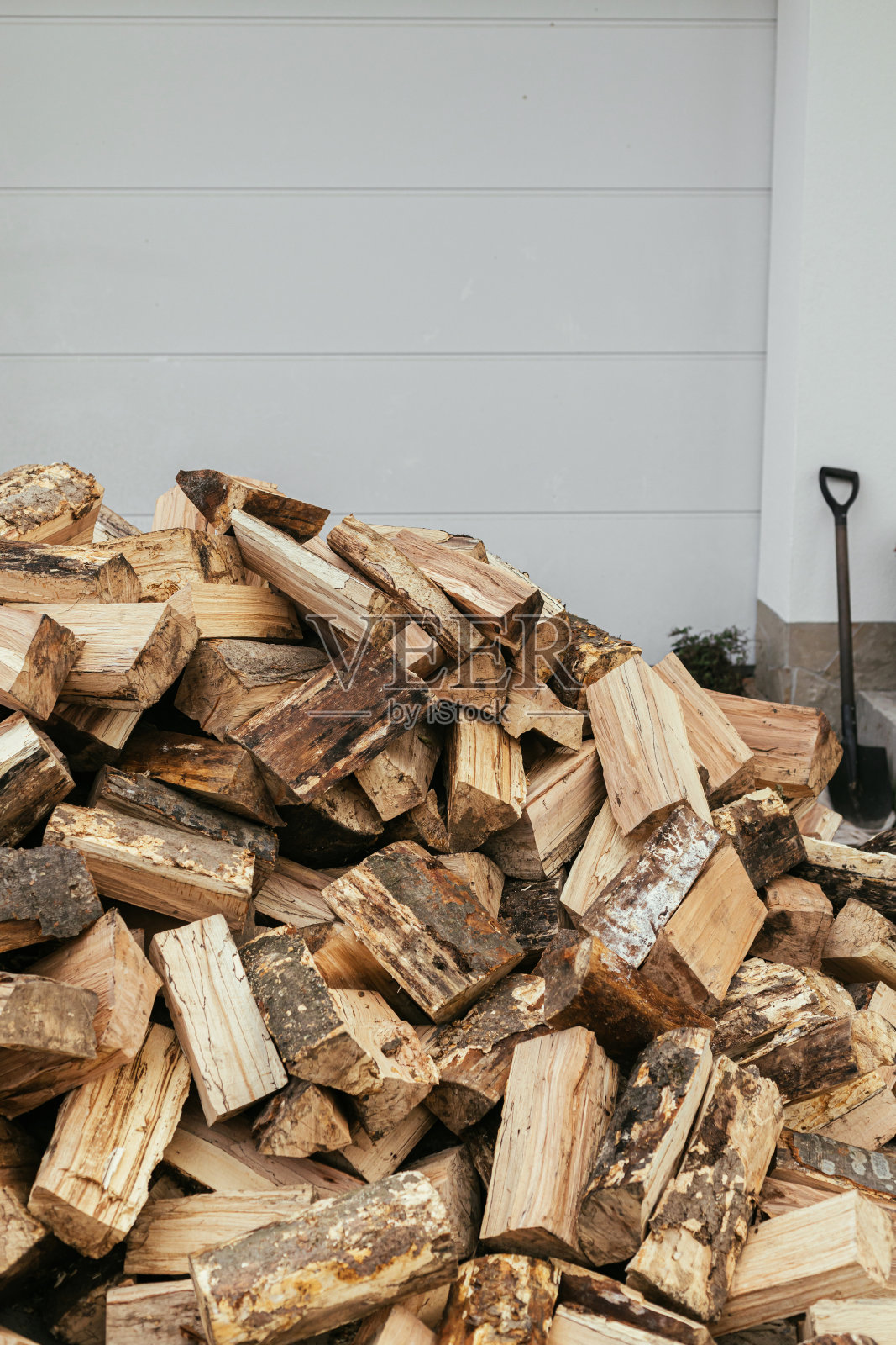 房子背景上的柴火。农舍外面的一堆柴火。壁炉取暖用的劈柴，替代煤气和电。照片摄影图片