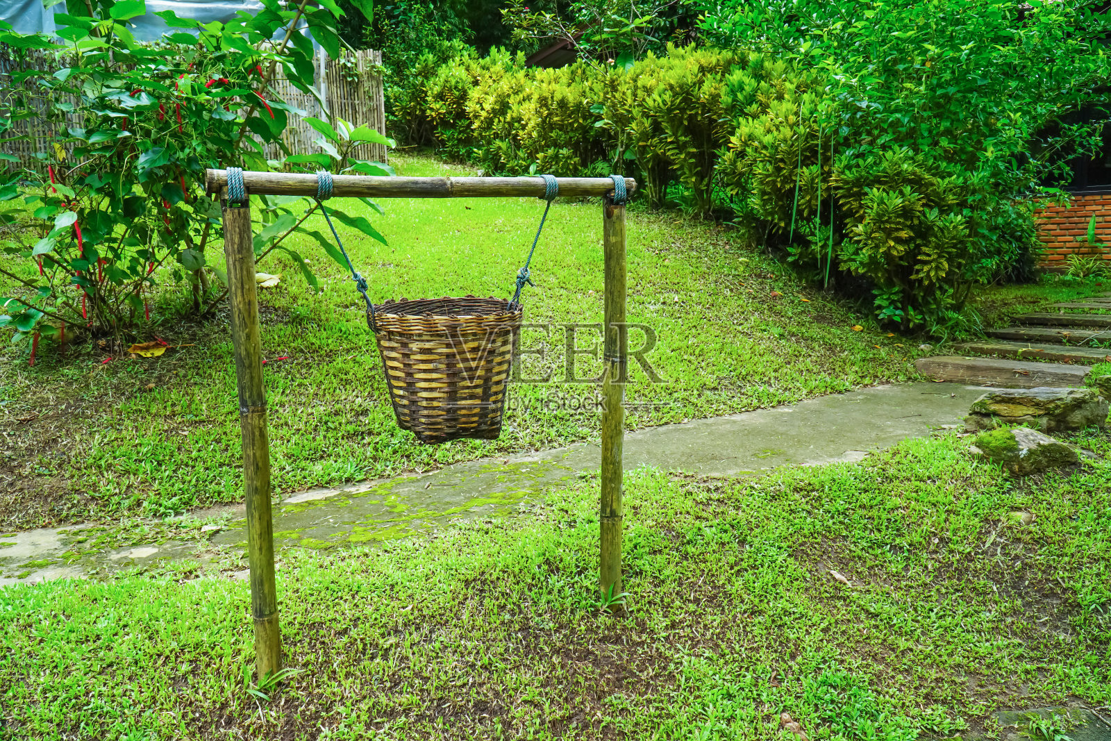 街道背景旁用绳子挂着垃圾桶。挂织木垃圾桶，系杆在人行道旁照片摄影图片
