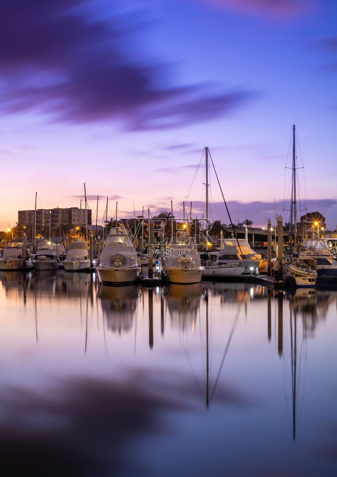 垂直拍摄的一个港口在晚上，船上的船，云，和日落的天空照片摄影图片