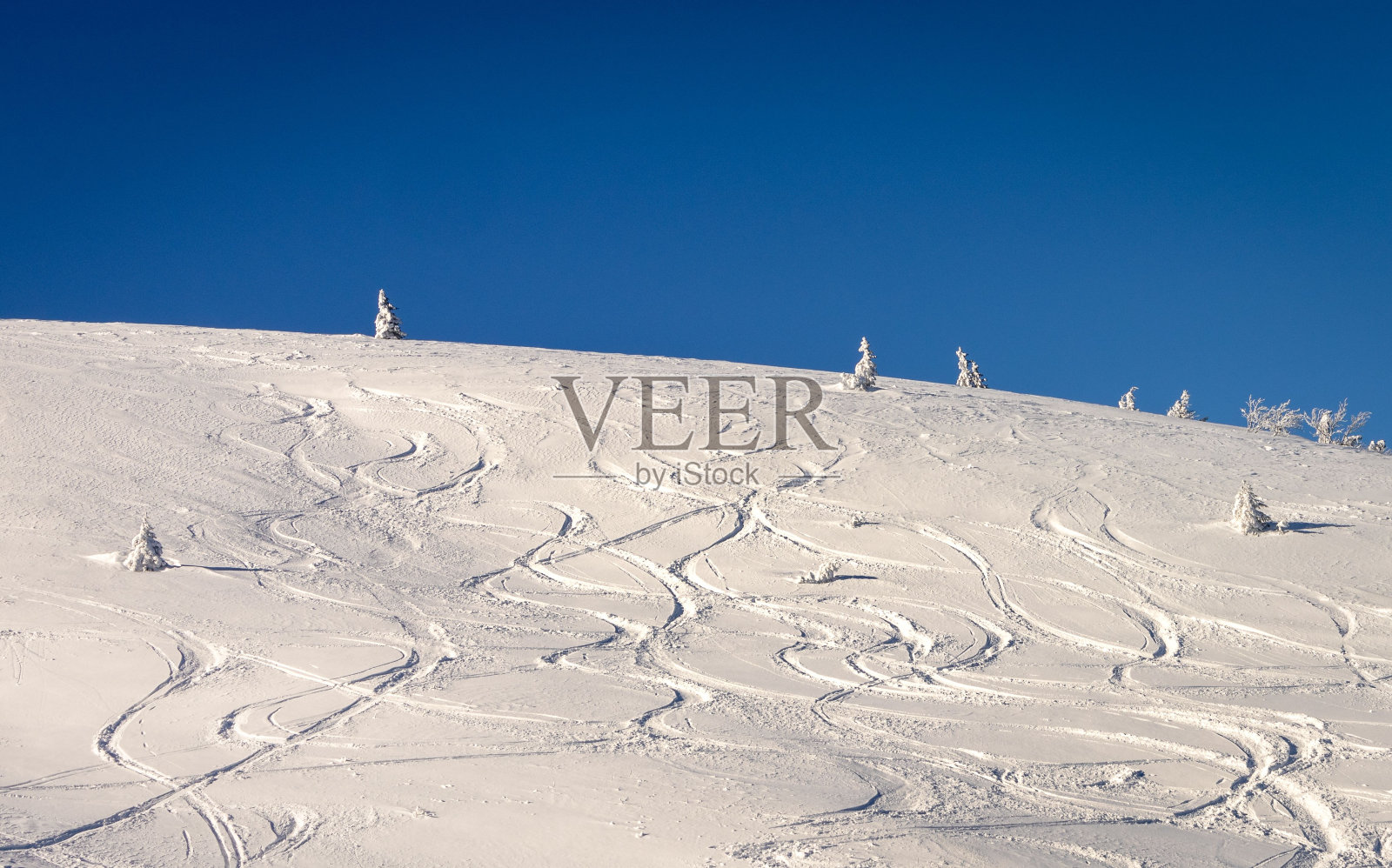 雪山的斜坡，上面有滑雪板的痕迹照片摄影图片