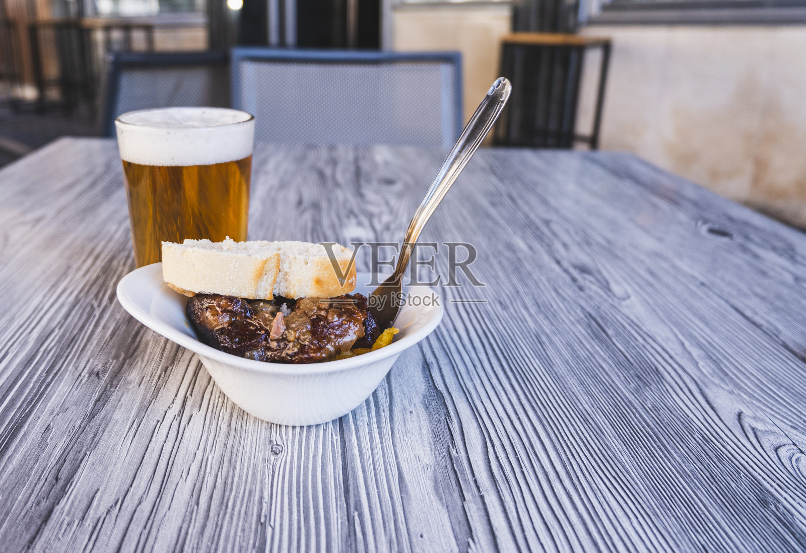 一杯新鲜啤酒的特写照片和一份猪脸的开胃酒。照片摄影图片