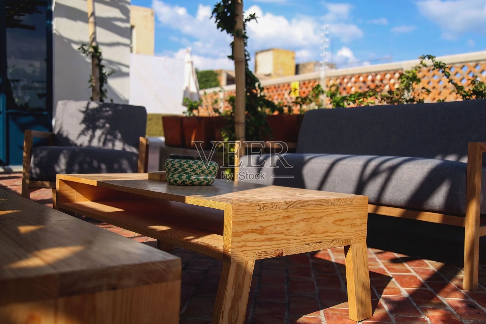 露台室外生活空间的视图，沙发和茶几在绿色庭院的背景照片摄影图片