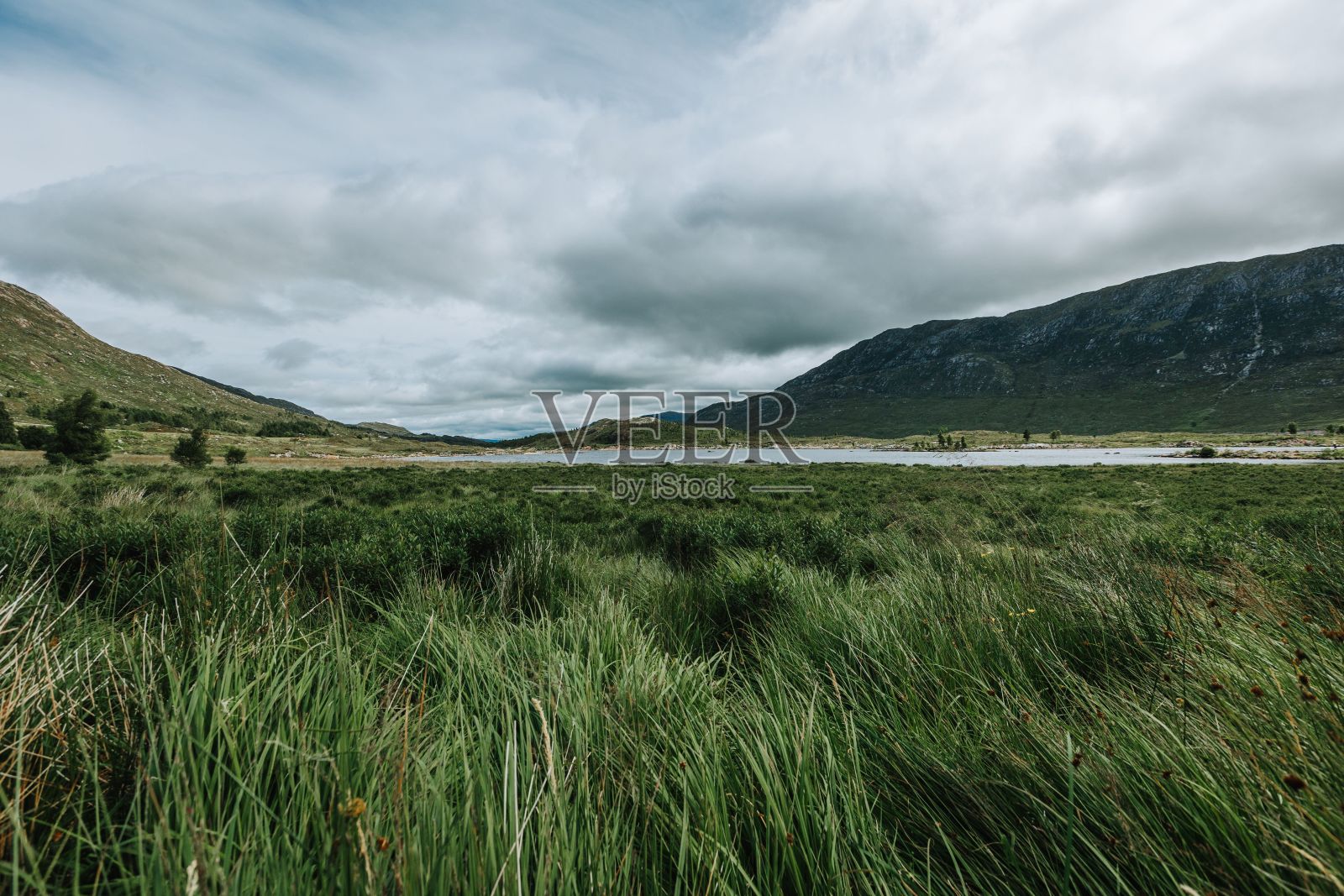 在一个多云的日子里，英国苏格兰的斯凯岛，被山和草包围的河流照片摄影图片