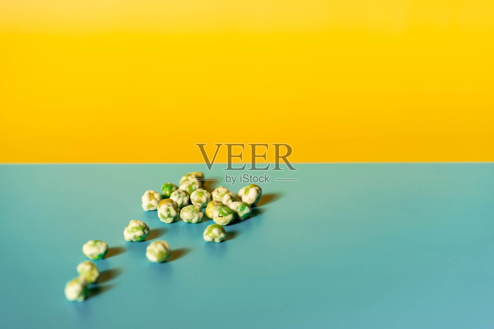 蓝色黄色背景上的绿色芥末豌豆特写镜头照片摄影图片