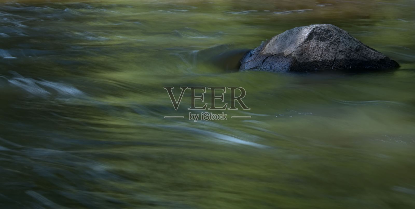 绿色海浪和一块石头的长时间曝光镜头照片摄影图片