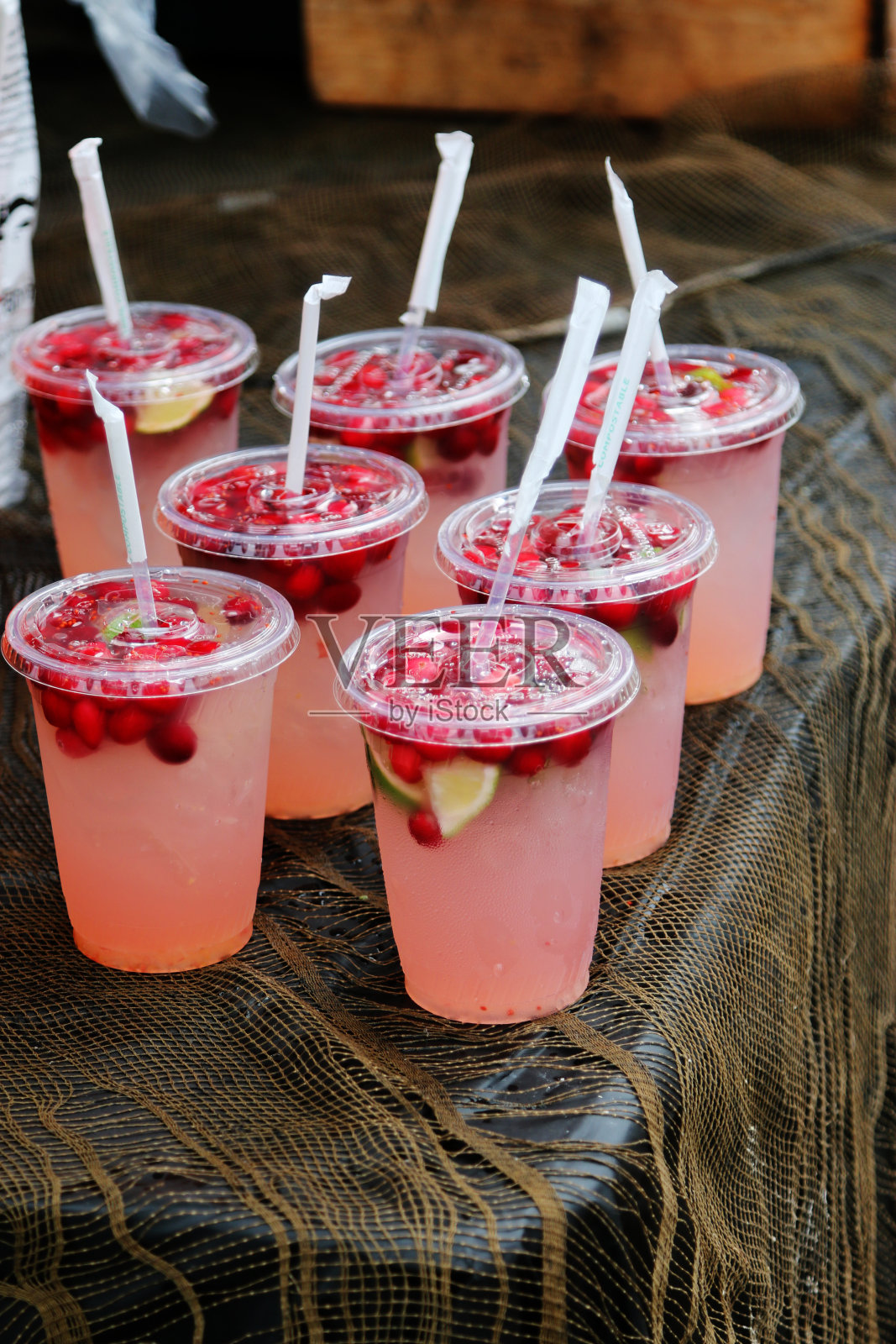 用塑料杯装的冰茶加浆果和柑橘照片摄影图片