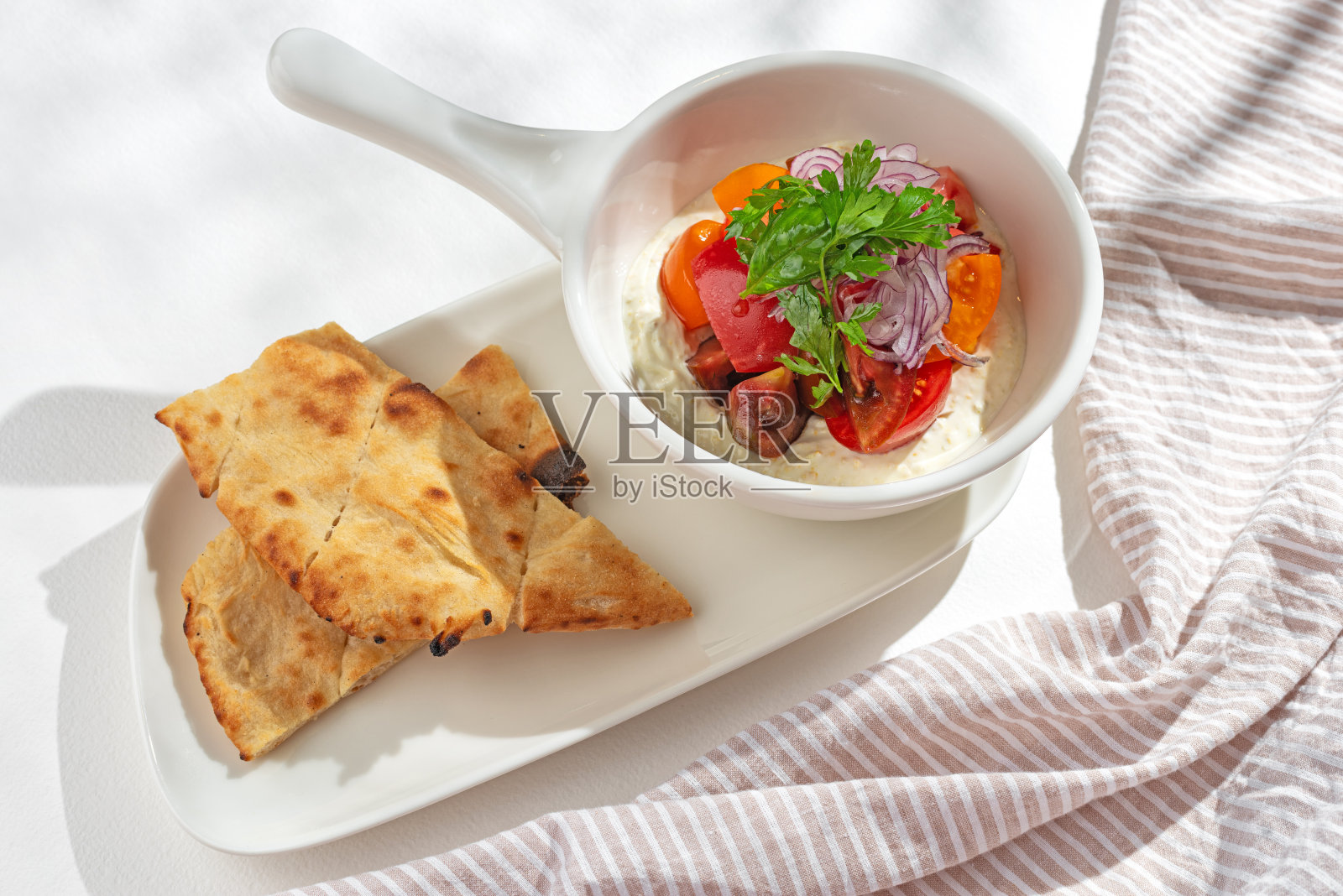 开胃菜。蔬菜沙拉:希腊酸奶配奶油芝士，番茄配浅底照片摄影图片