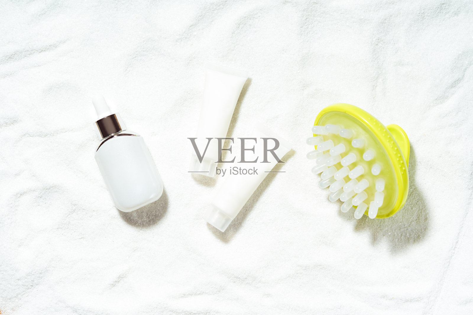 基于天然海洋化妆品和矿物质概念的水疗治疗。用白色化妆瓶和按摩刷放在白色沙滩上制作而成。前视图。照片摄影图片