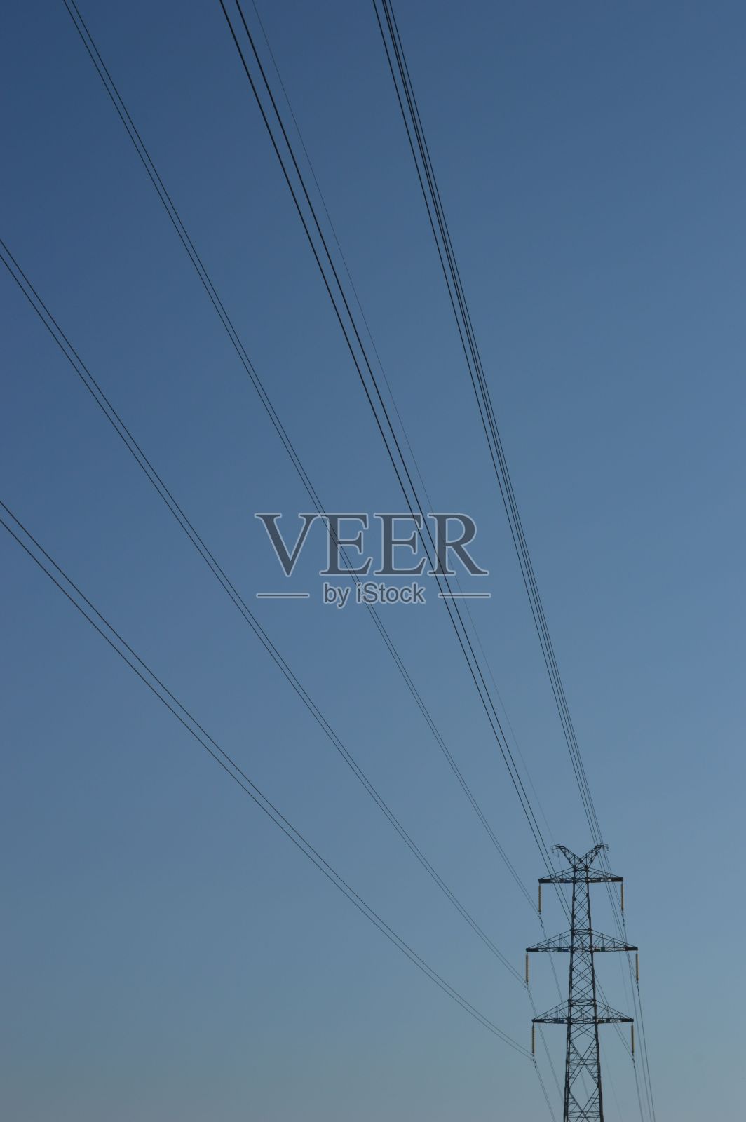 低角度拍摄的电柱和电线与蓝色的天空背景照片摄影图片