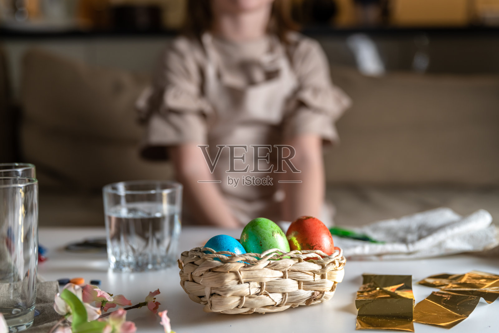 女孩在家里的厨房里为复活节染彩蛋照片摄影图片