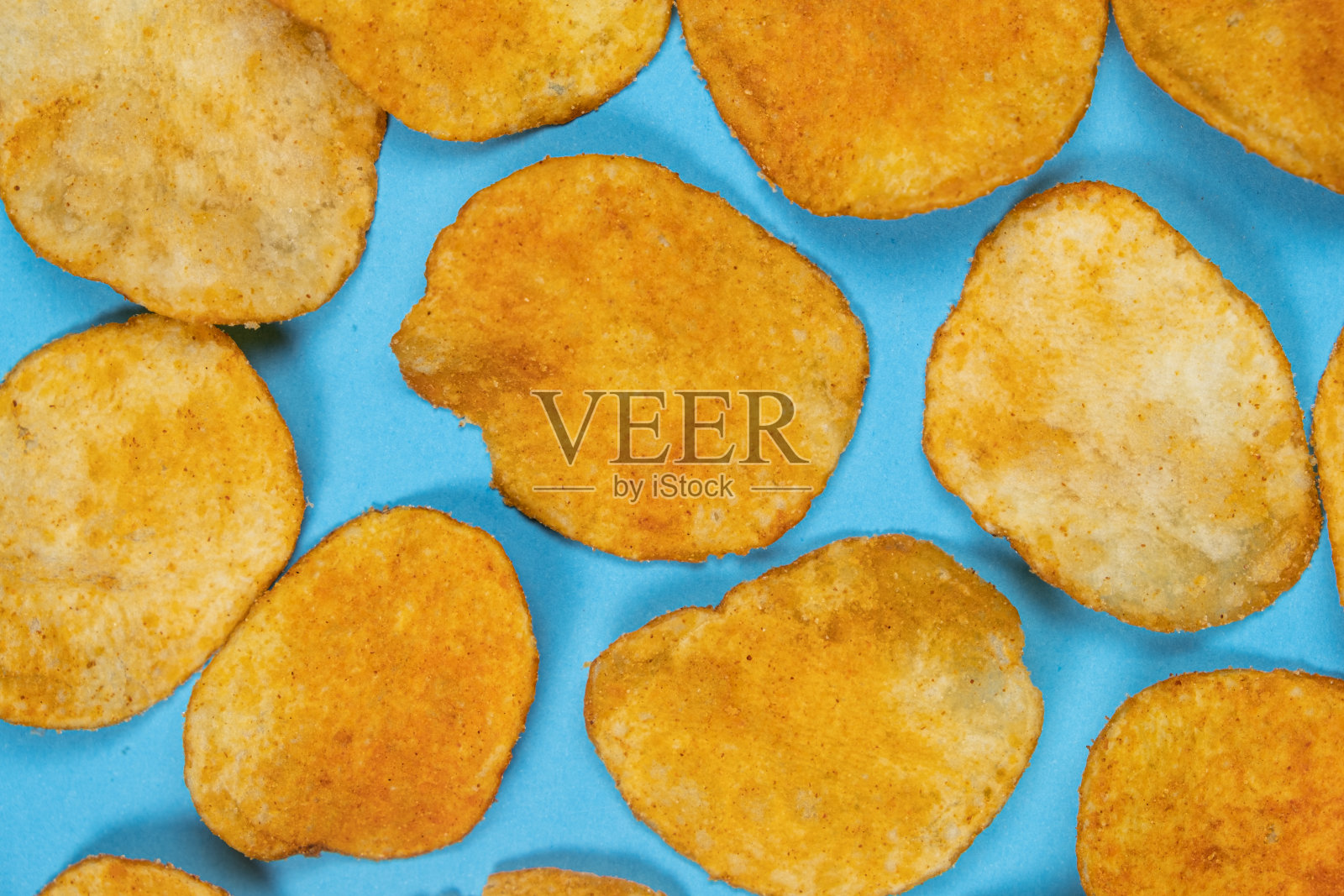 美味酥脆的薯片与香料在蓝色背景，俯视图照片摄影图片