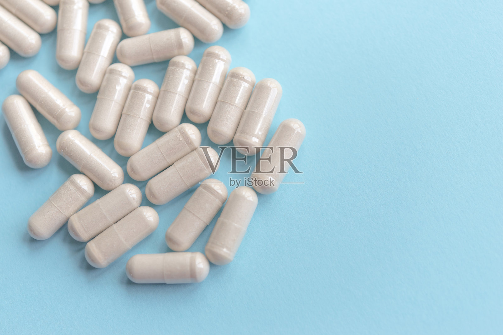 蓝色桌子上放着白色药片。医疗、药学和保健概念。副本的空间。文字或标志的空间。为特别优惠做模型，如广告或其他想法。照片摄影图片