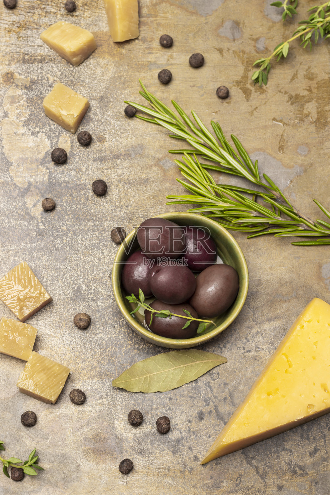 碗里的橄榄，一枝迷迭香和几片奶酪。照片摄影图片