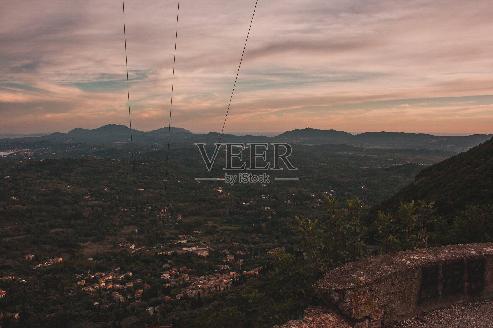 科孚岛,希腊。在傍晚夕阳的余晖中，从上空俯瞰这座城市。绿色的树照片摄影图片