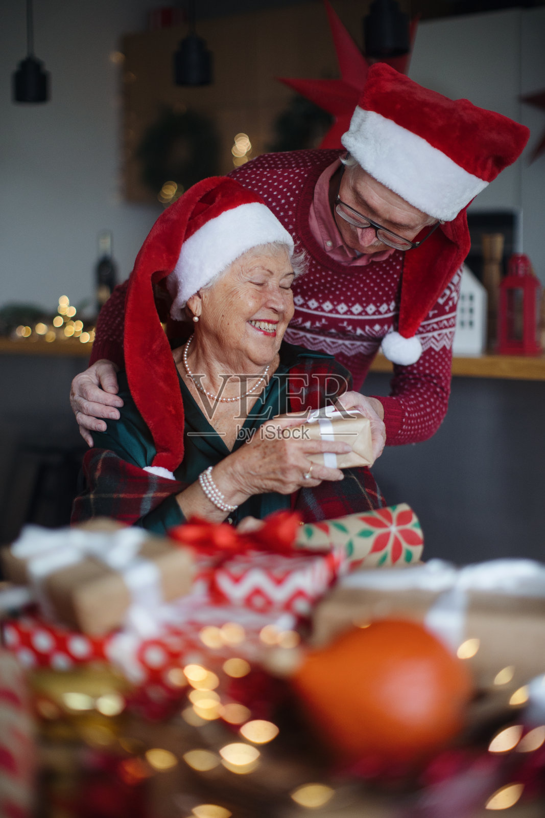 老夫妇庆祝圣诞节，互赠礼物。照片摄影图片
