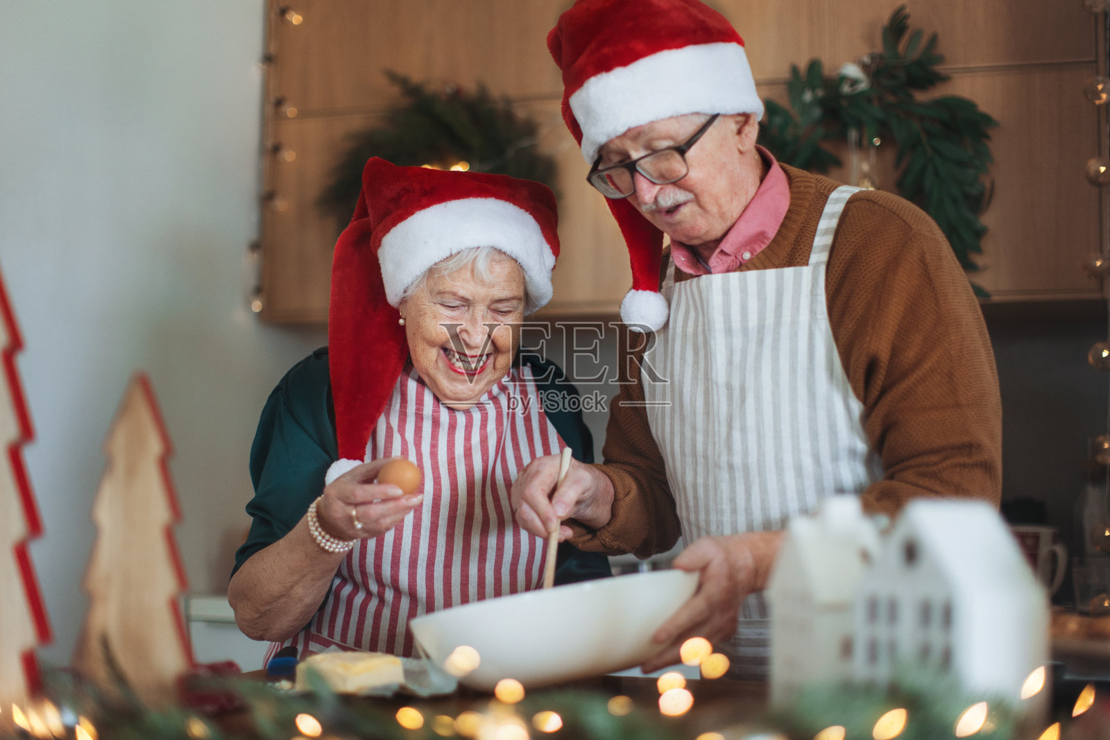 快乐的老人们一起烤圣诞蛋糕。照片摄影图片