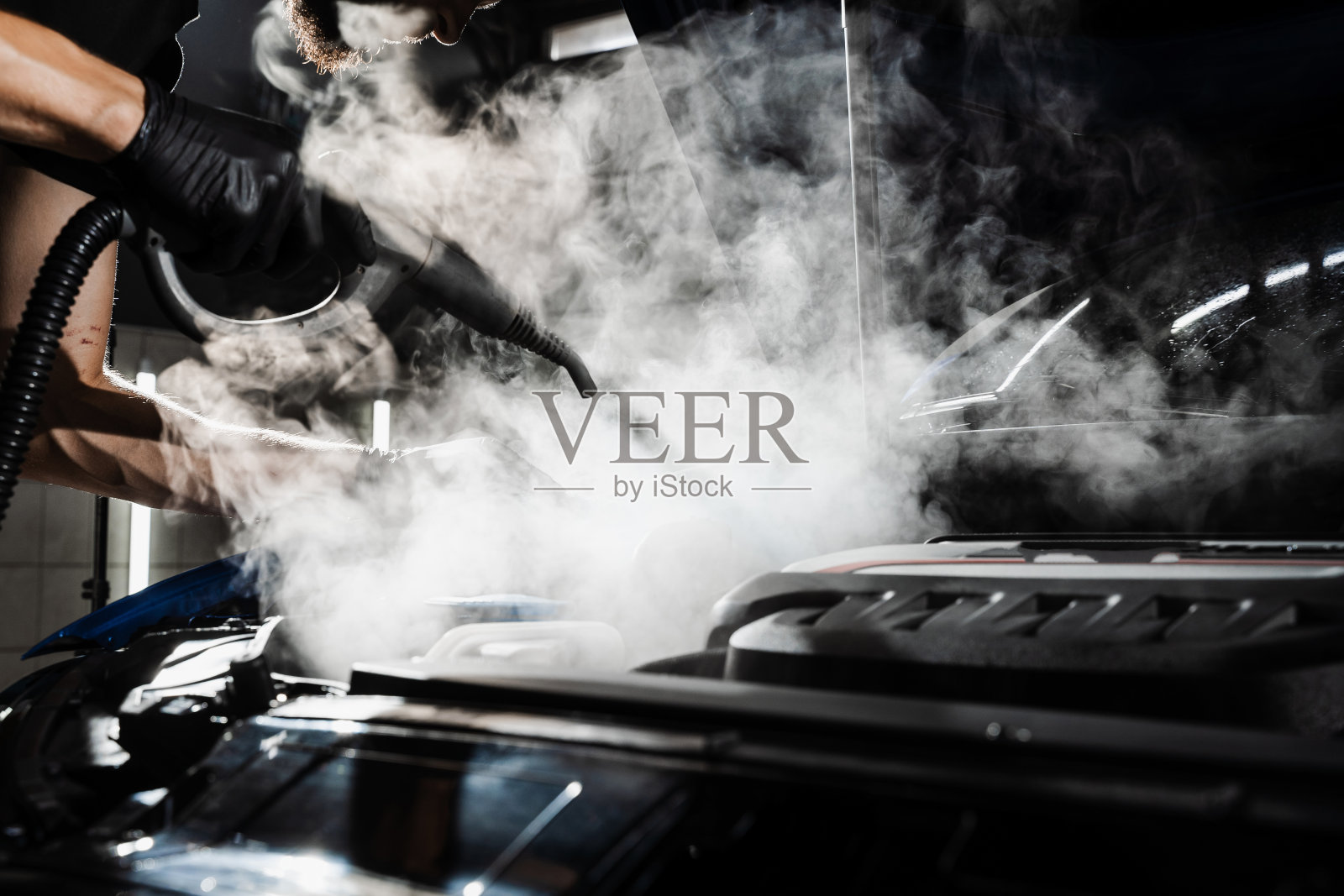 蒸汽清洗汽车发动机上的灰尘和污物的过程。在详细的汽车服务中，汽车电机的蒸洗。照片摄影图片