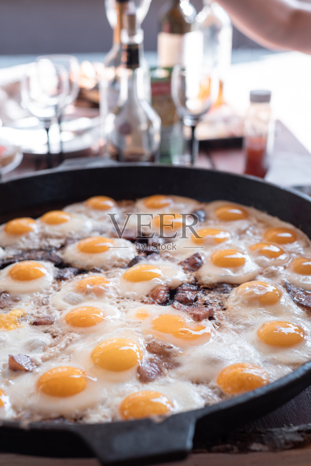 公司正在外面吃早餐。巨大的炒鸡蛋和培根在煎锅特写。照片摄影图片