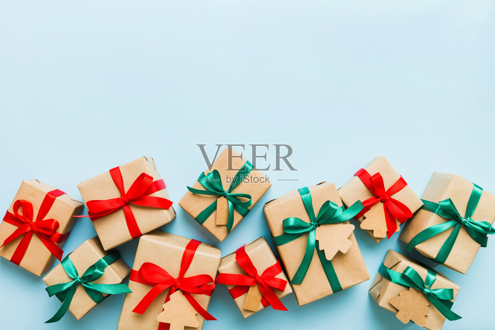 用彩色丝带用纸包装圣诞或其他节日手工制作的礼物。礼品盒，彩色桌子上的礼品装饰，顶视图与复制空间照片摄影图片