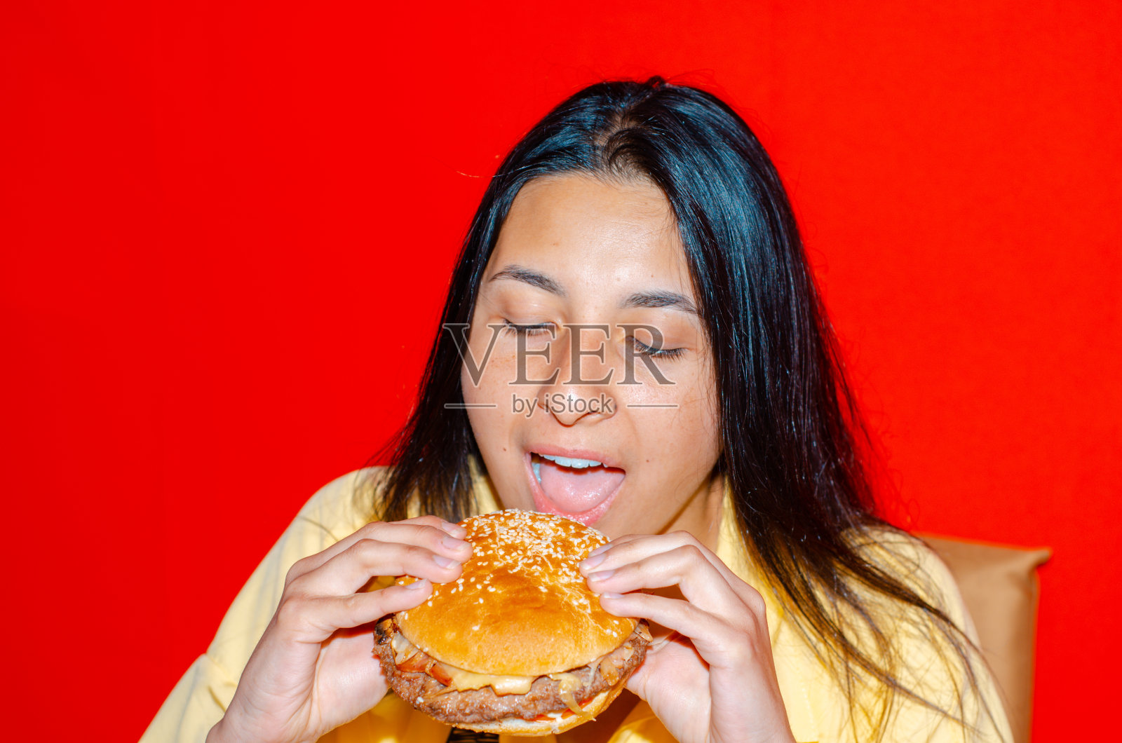 吃着红底色汉堡的女人照片摄影图片