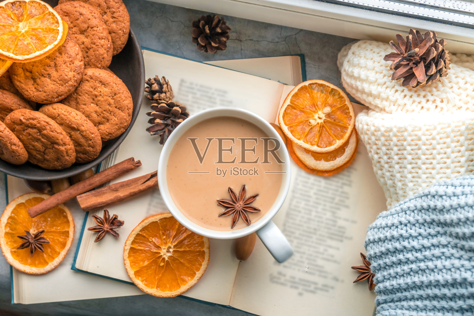 平躺在窗边，有一大杯咖啡，书和针织毯子照片摄影图片