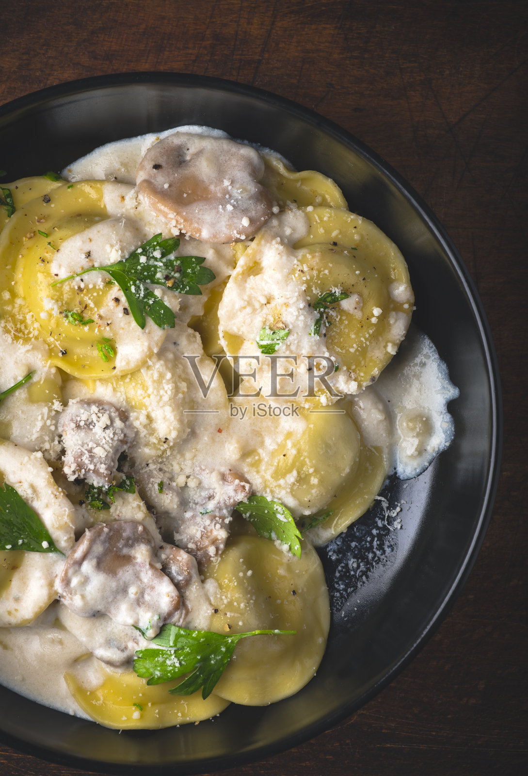 意式馄饨配蘑菇奶油酱蘑菇馅配香草和胡椒粉。冬季食谱的寒冷季节的意大利菜照片摄影图片