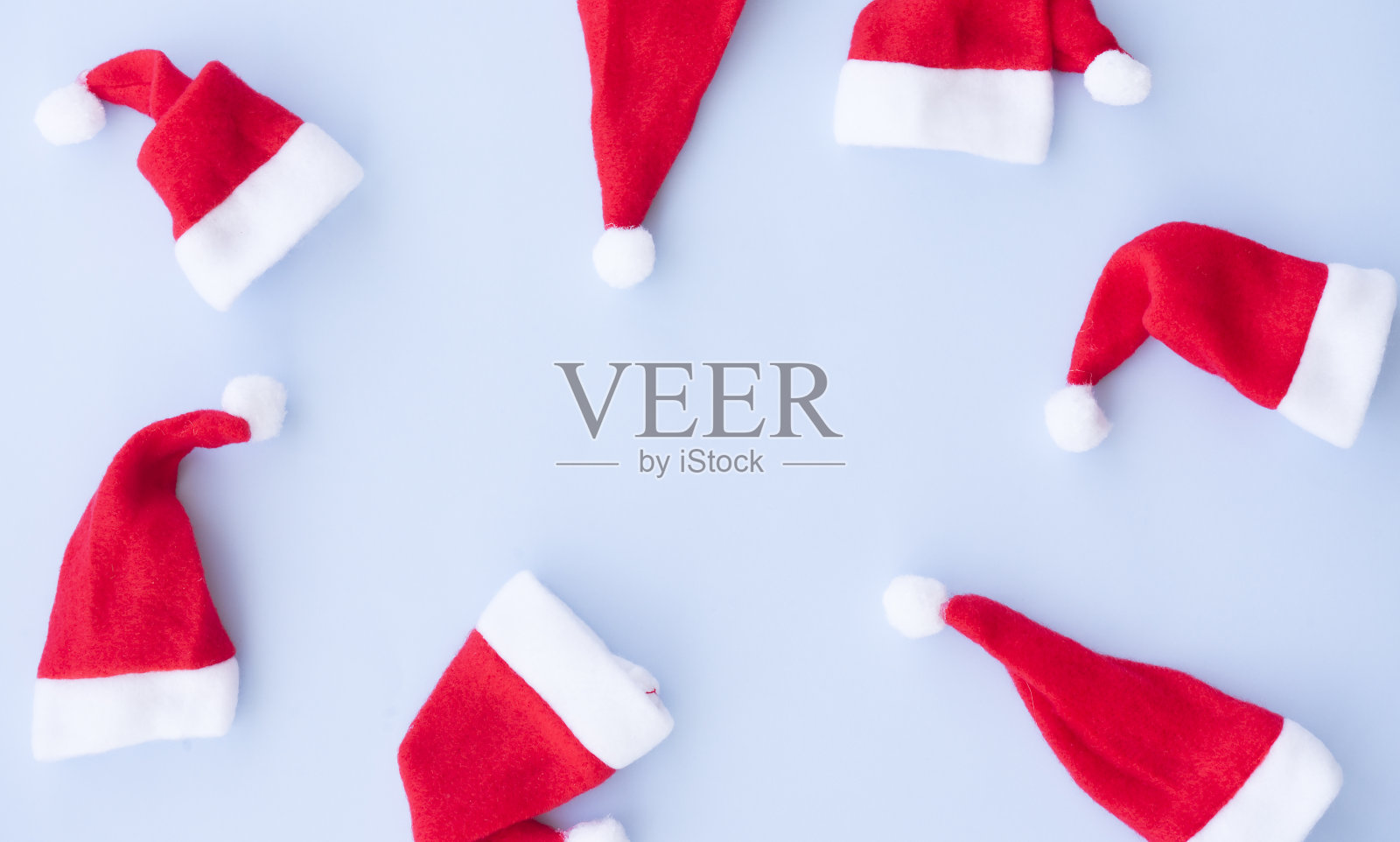 蓝色背景上有许多圣诞老人的帽子照片摄影图片