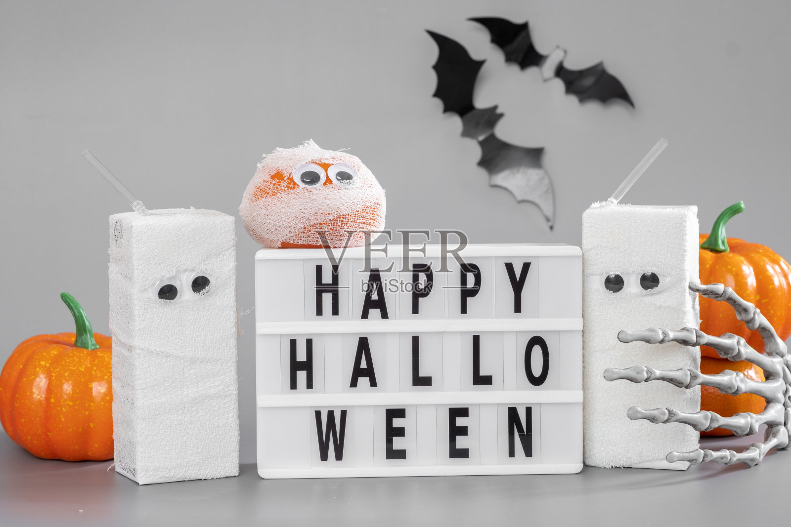 快乐万圣节灯箱标牌板与南瓜，蝙蝠和糖果在灰色的背景照片摄影图片