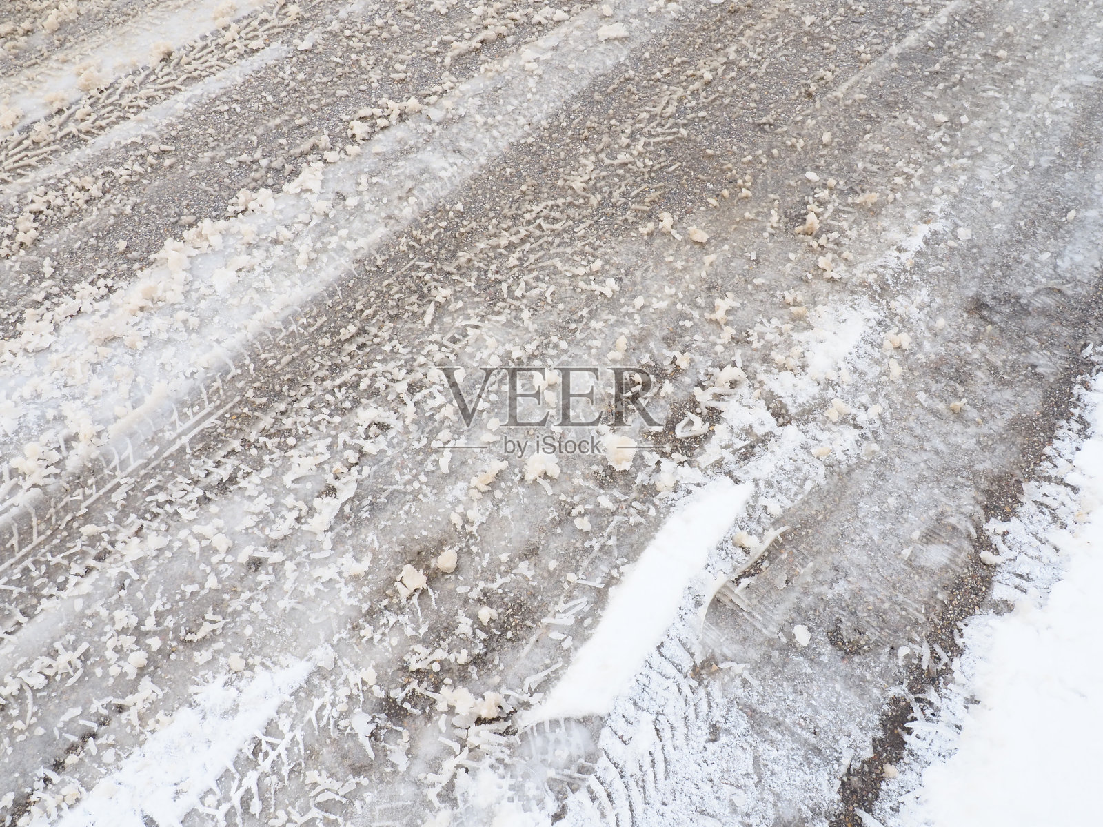 岔路:环形路口的岔路或侧边路边的雪堆。坏天气。雪在沥青。困难的驾驶和交通状况。冬天路上的雪泥。汽车的制动距离照片摄影图片