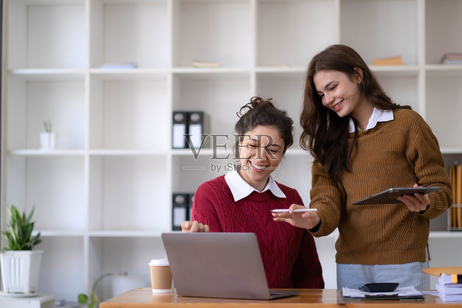 两位年轻的亚洲女商人在办公室交谈、咨询、讨论与新创业公司合作的项目想法、陈述、分析计划、营销和投资。照片摄影图片