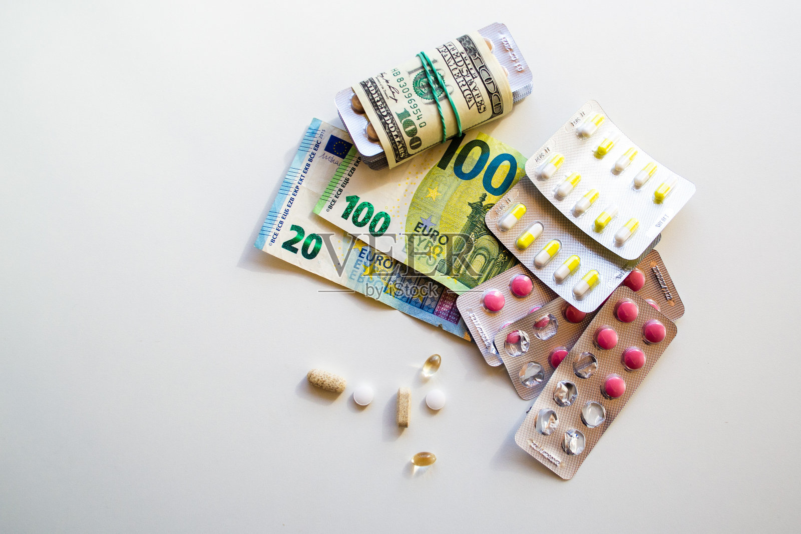 片剂和胶囊。纸币作为制造药品的成本照片摄影图片