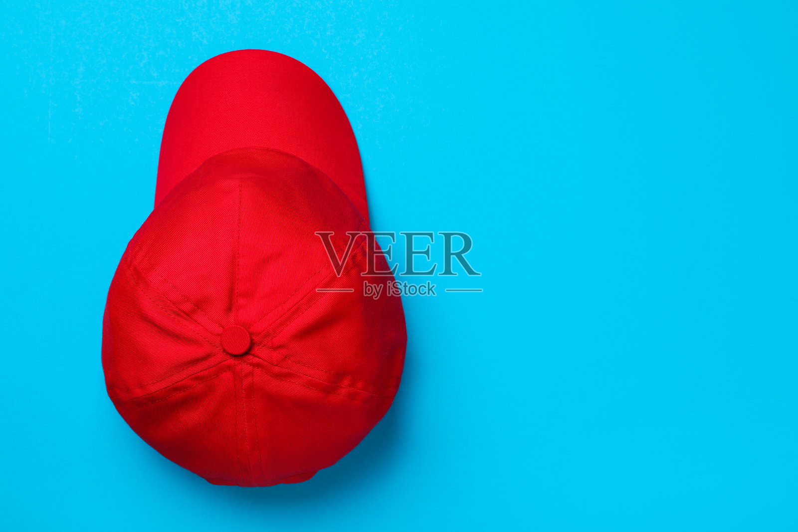 棒球帽在浅蓝色背景，俯视图。空间的文本照片摄影图片