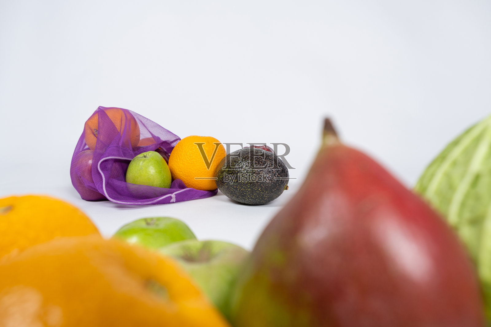 白色背景上的水果和蔬菜的织物网。照片摄影图片