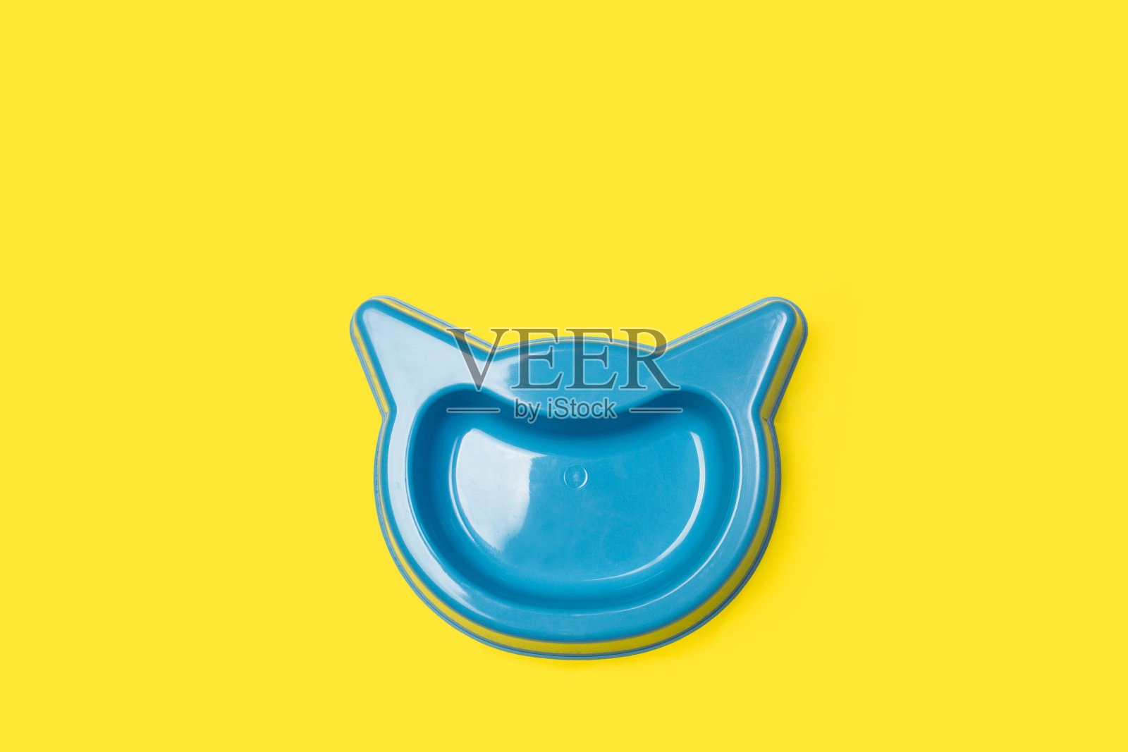 蓝色的猫头宠物碗在黄色的背景照片摄影图片