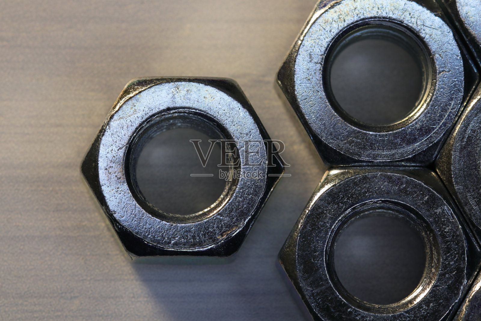 金属六角螺母在纹理表面的特写照片摄影图片