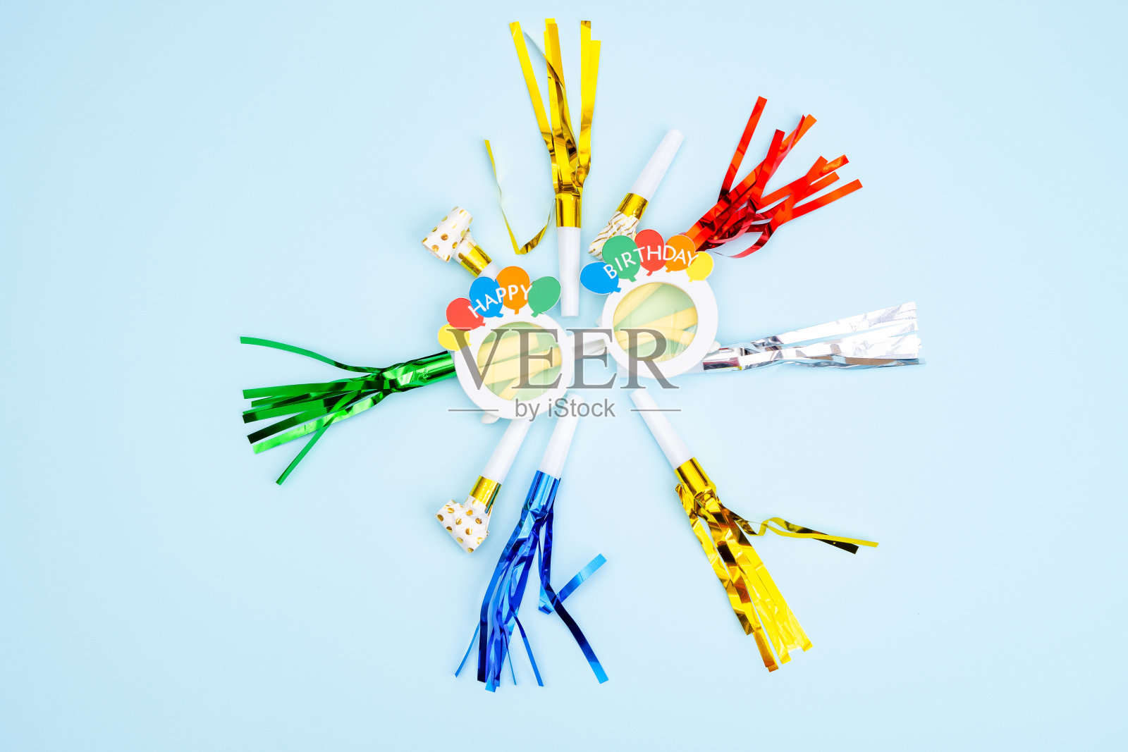 生日晚会的背景。邀请函，派对用品，生日哨子，派对眼镜和帽子，礼品盒，旗帜和餐巾。照片摄影图片