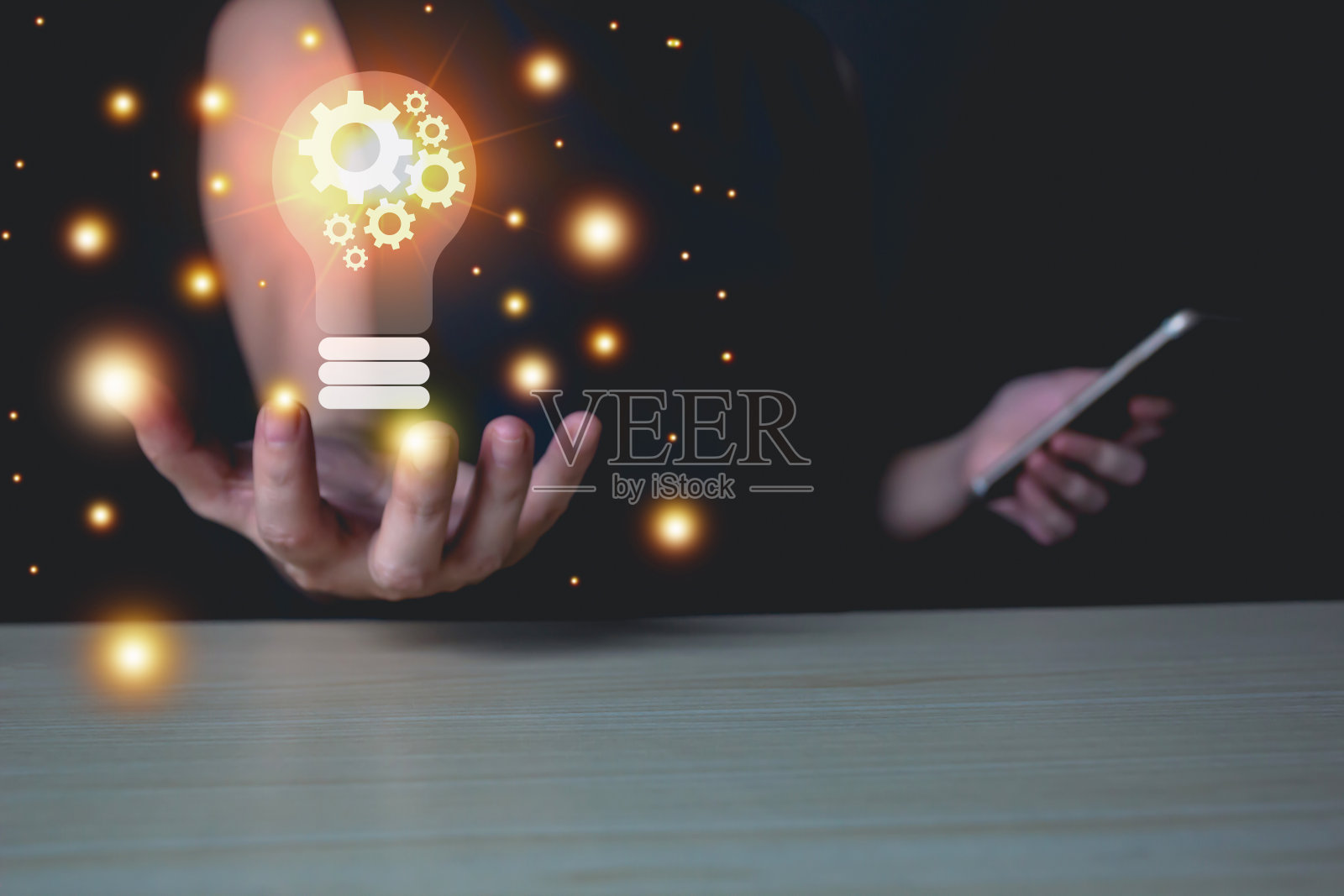 亚洲妇女摊开手掌和灯泡与齿轮和发光的手，另一只手拿着智能手机。创意和想法的概念。照片摄影图片