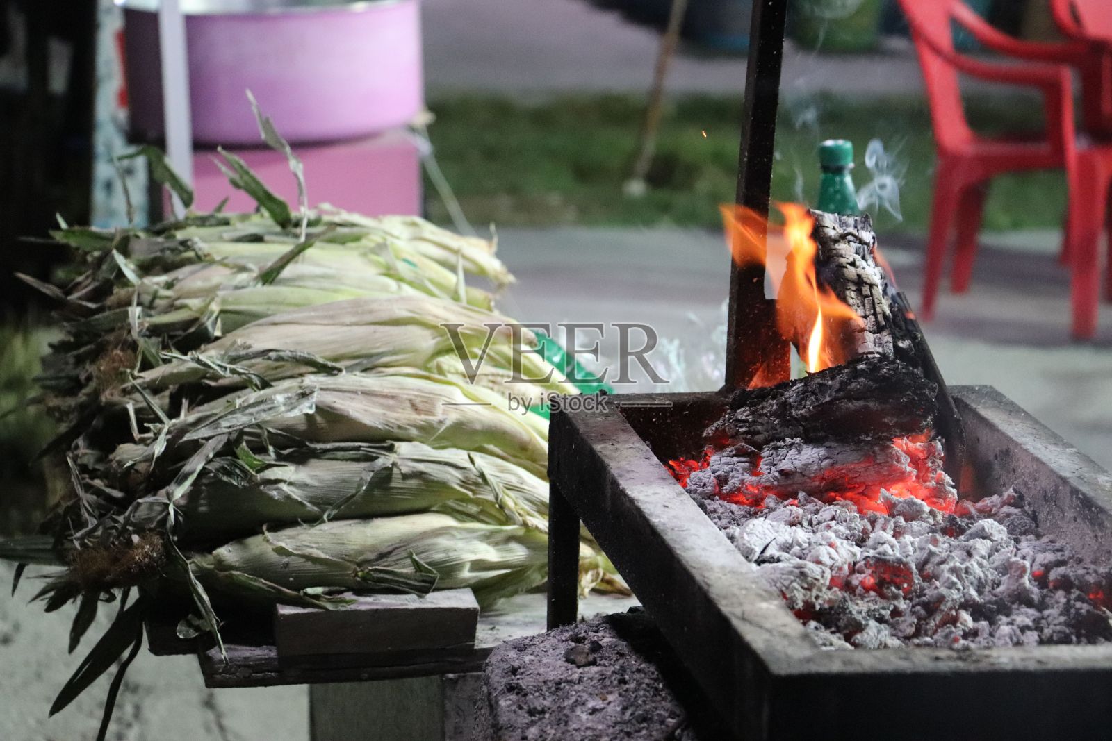 近距离拍摄的烧烤火旁边的一堆未耕种的玉米照片摄影图片