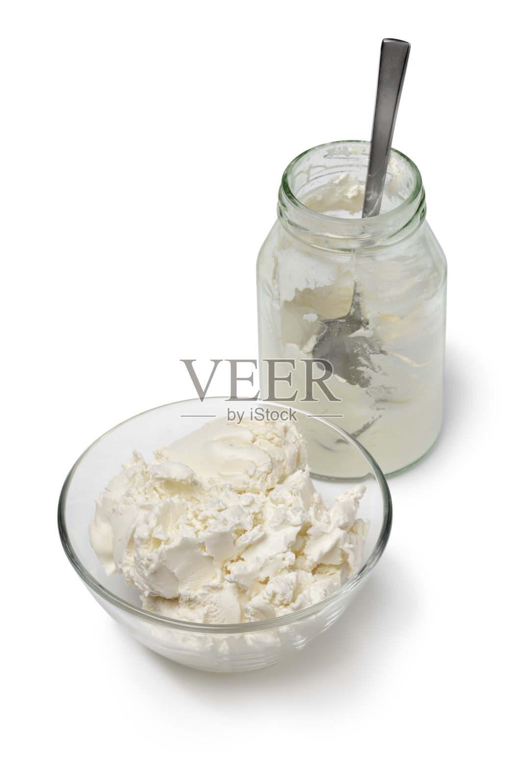 玻璃碗和瓶子与凝结的奶油接近的白色背景照片摄影图片