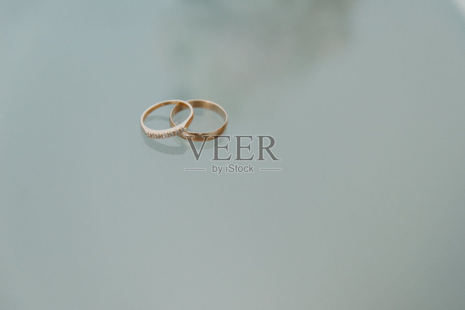 两枚结婚戒指在地板上形成对比照片摄影图片