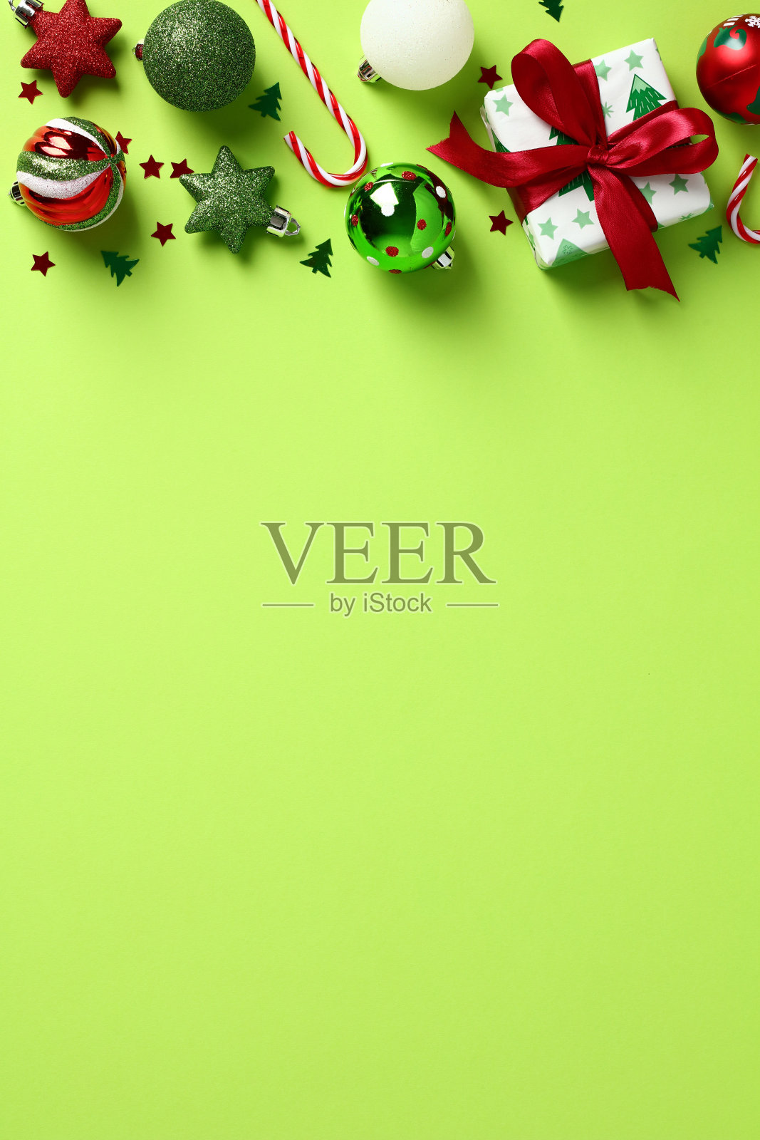 圣诞绿色垂直背景与礼品盒，糖果拐杖，小玩意儿，星星，五彩纸屑。圣诞海报、横幅设计。照片摄影图片