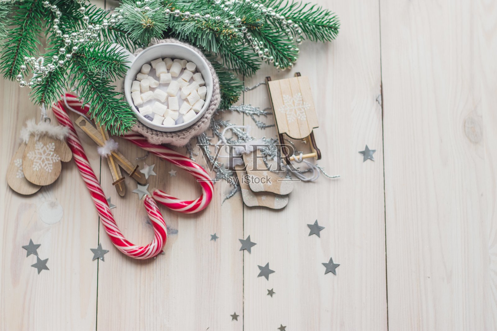 桌上放着一大杯棉花糖和拐杖糖，周围是圣诞装饰照片摄影图片