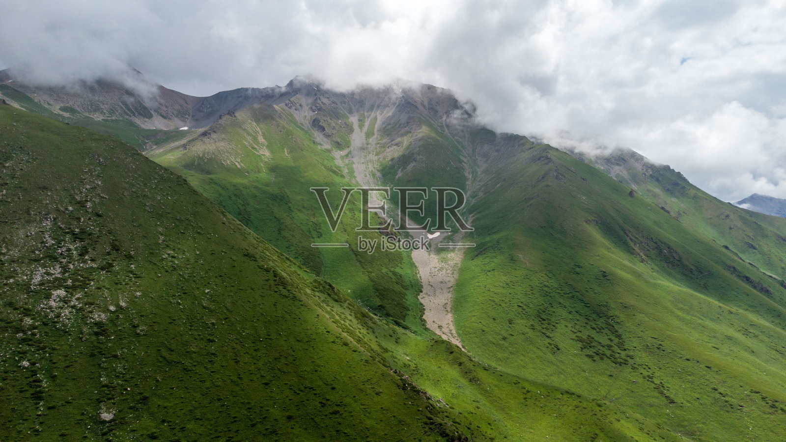 在多云的日子里，巨大的绿色山丘的美丽景色照片摄影图片