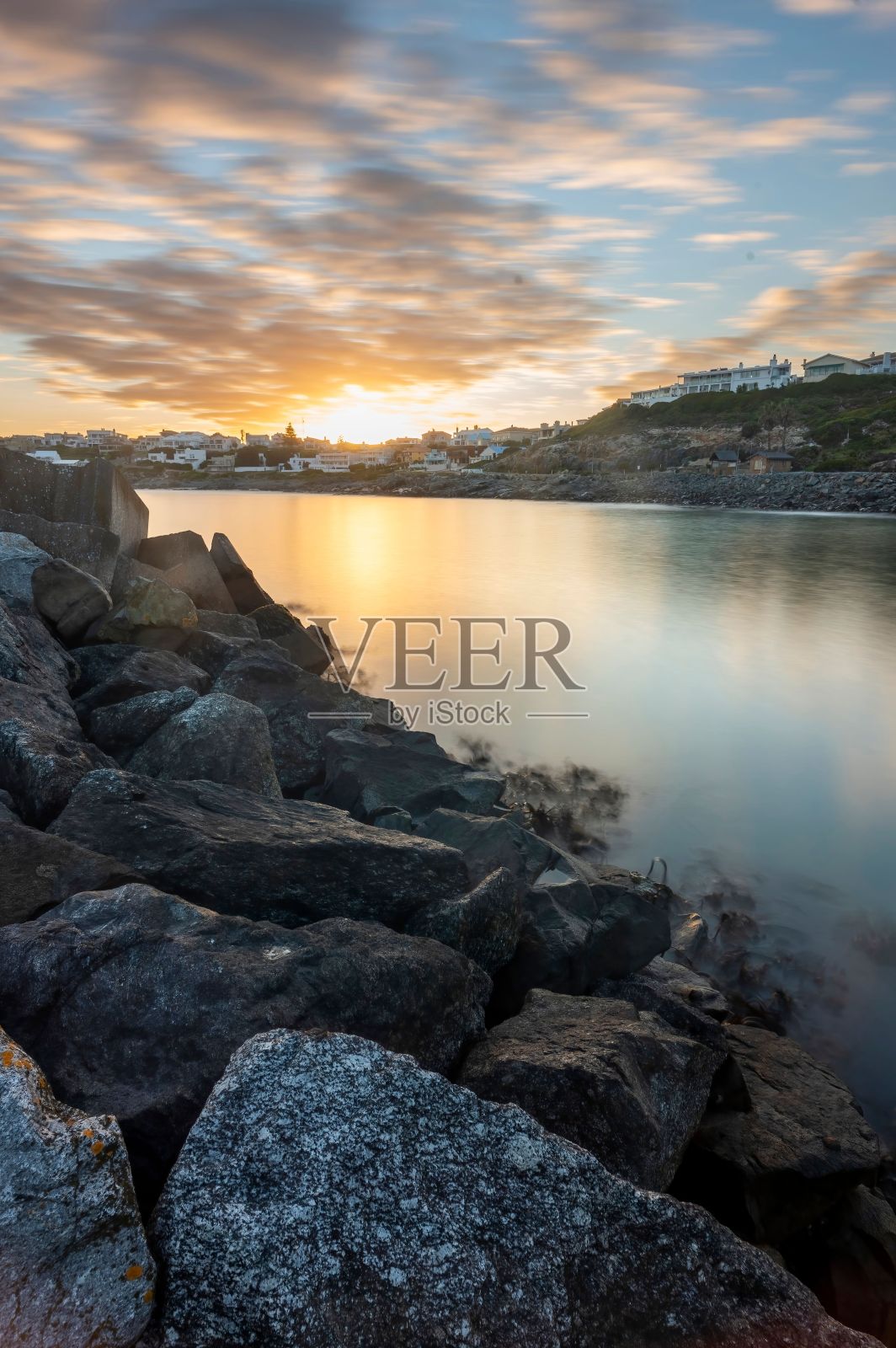 日落时美丽的海景和岩石海岸照片摄影图片