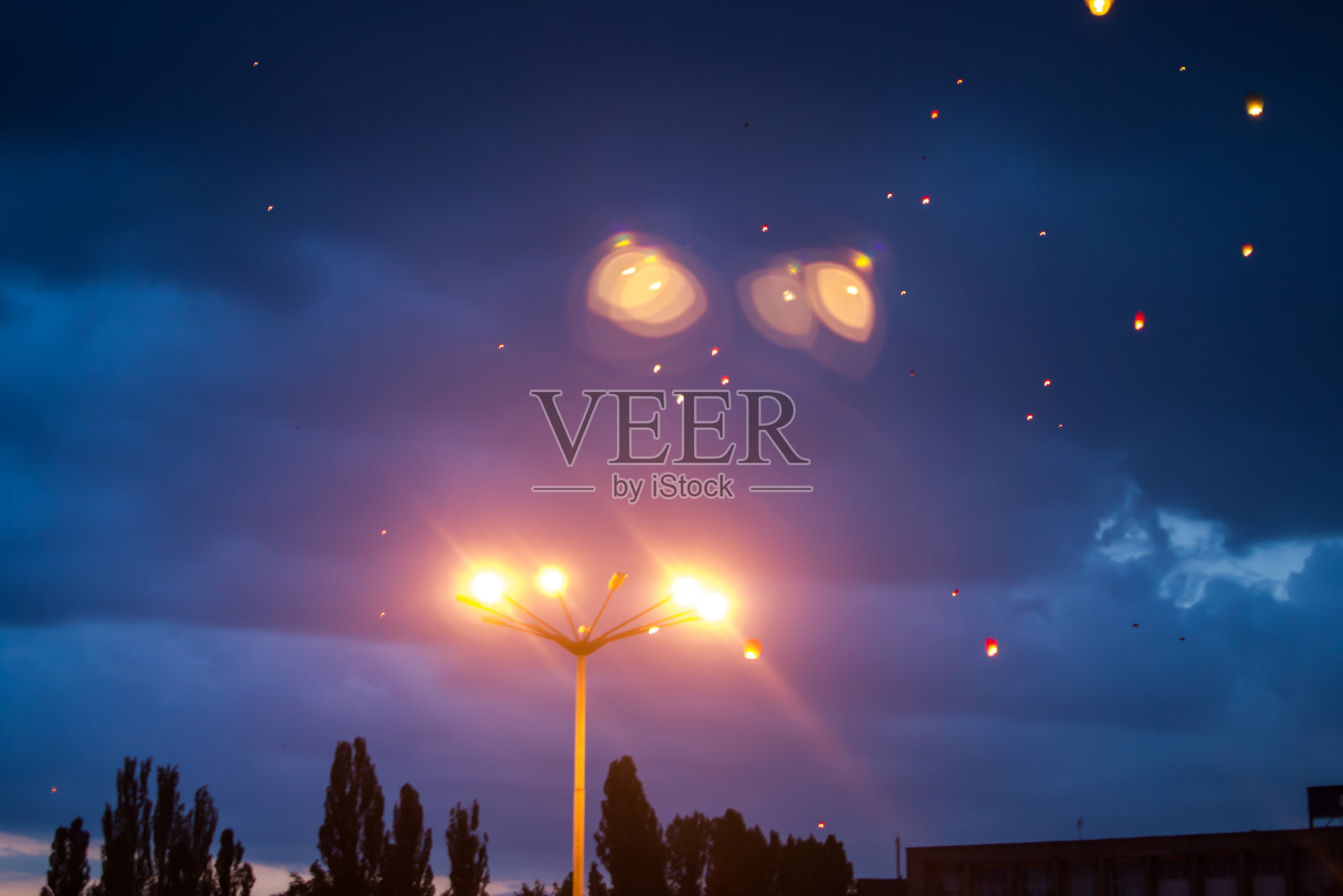 傍晚日落时分，人们和亲朋好友一起放飞传统灯笼。照片摄影图片