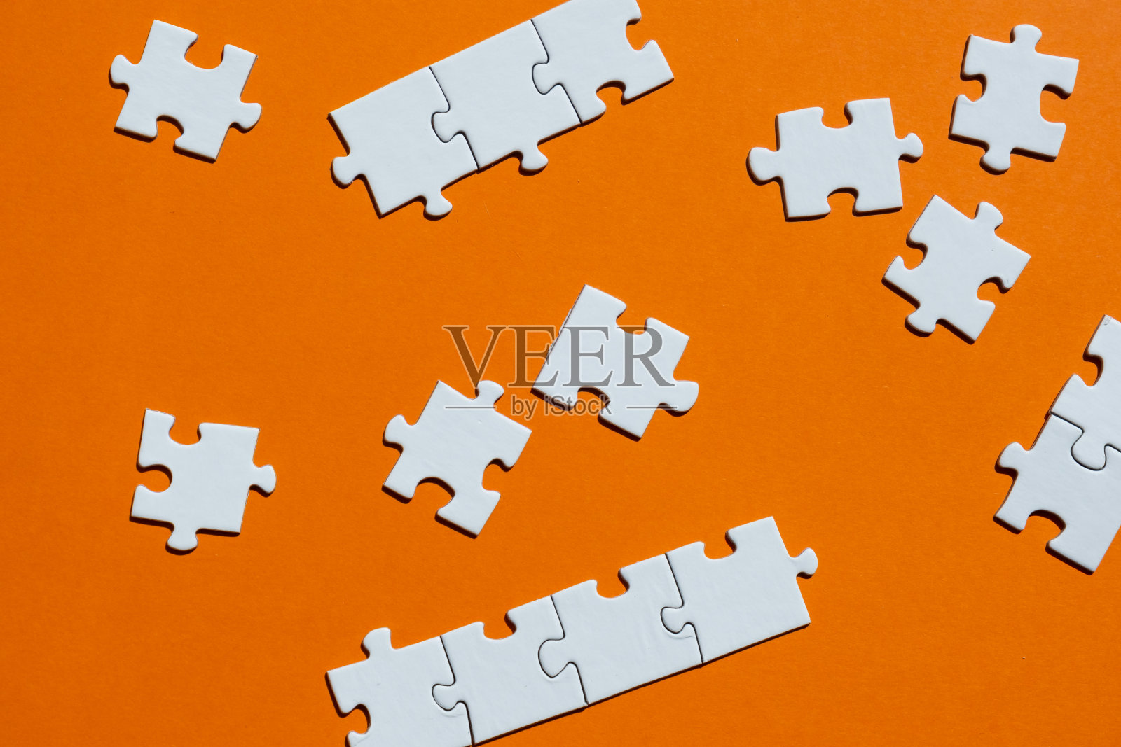橙色背景上的白色拼图。棋盘游戏的概念。照片摄影图片