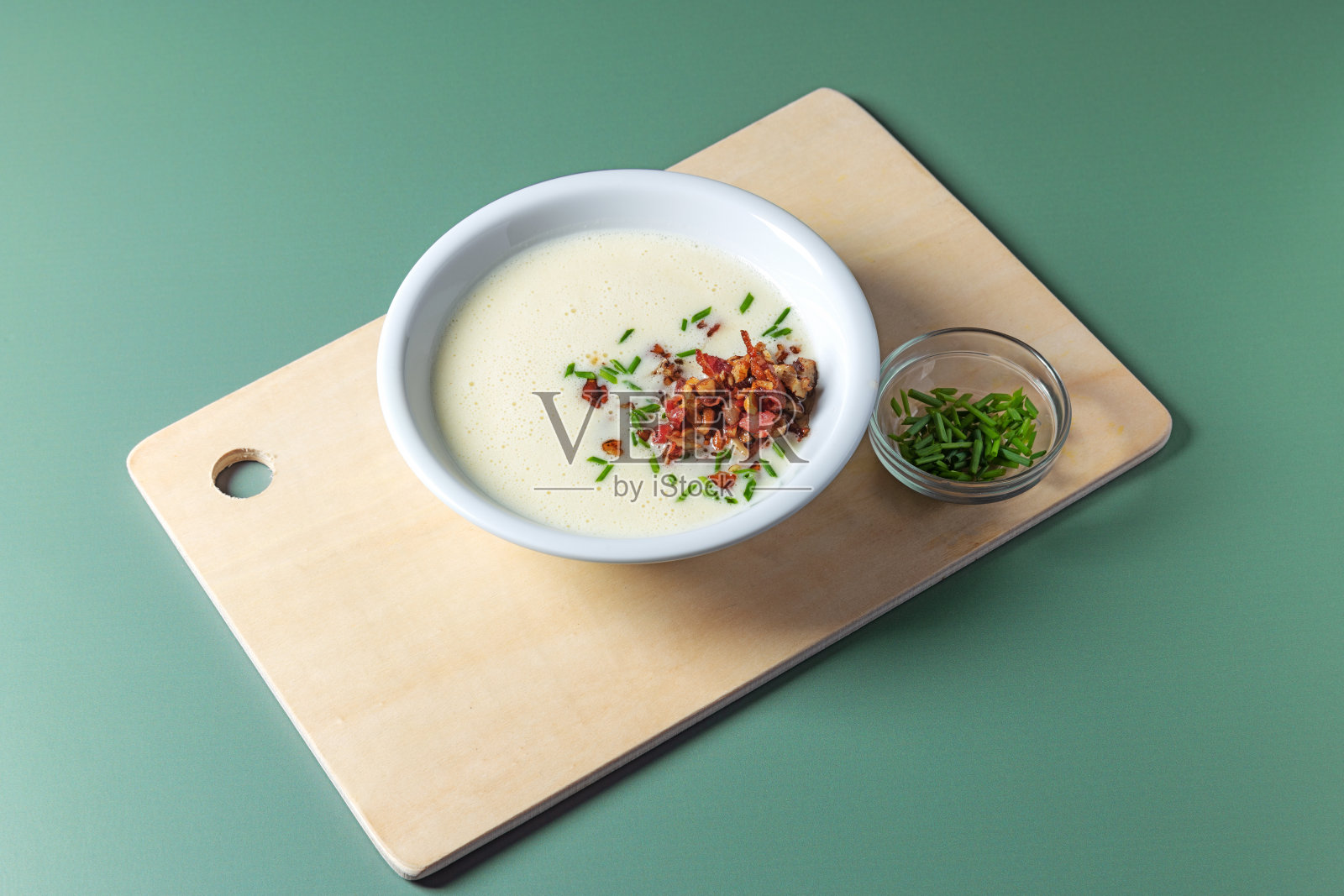 汤奶油与西班牙香肠片在绿色背景。照片摄影图片