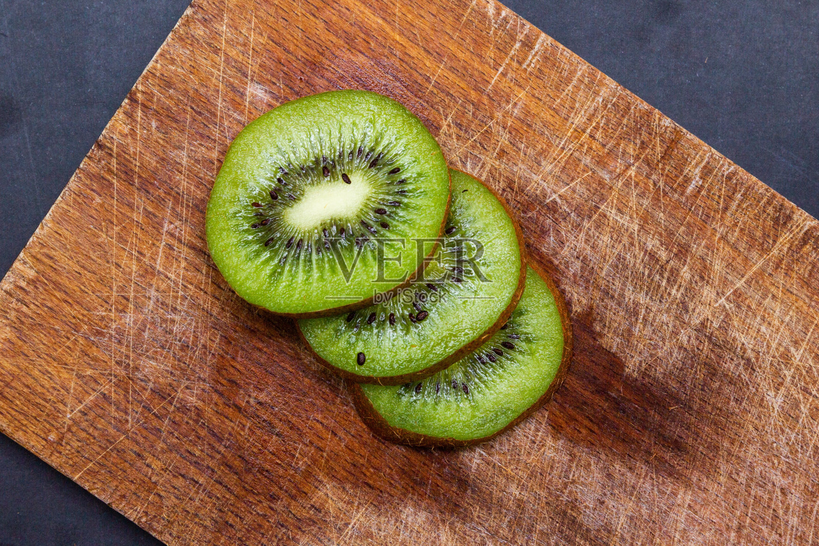 高角度拍摄切片新鲜猕猴桃在一个木制砧板照片摄影图片